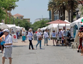 people wandering to tents at an outdoor art show