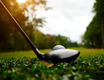 close up on a golf ball and club