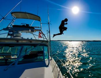 Kid jumping off boat into water