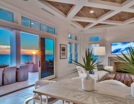 living room of 30A vacation rental looking out window at sunset over Gulf of Mexico
