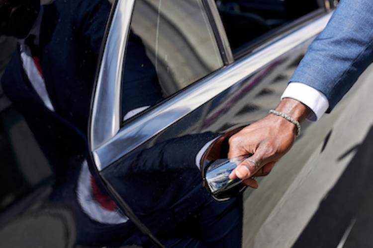 private driver opening the door of luxury black car