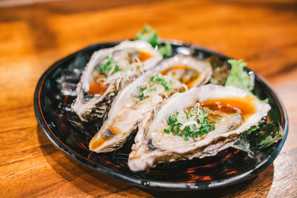 3 raw oyster freshly opened and served on dish at Japanese restaurant