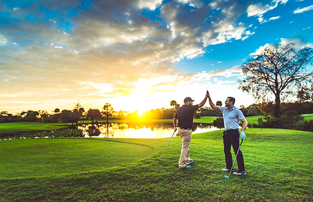 two men high five on a golf course in Florida