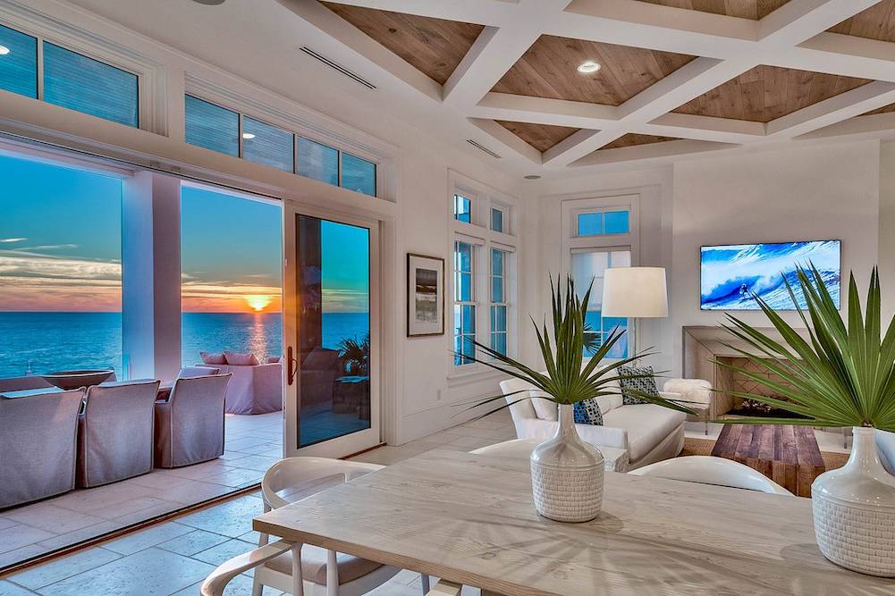 beautiful living room with view of ocean out large floor to ceiling windows 
