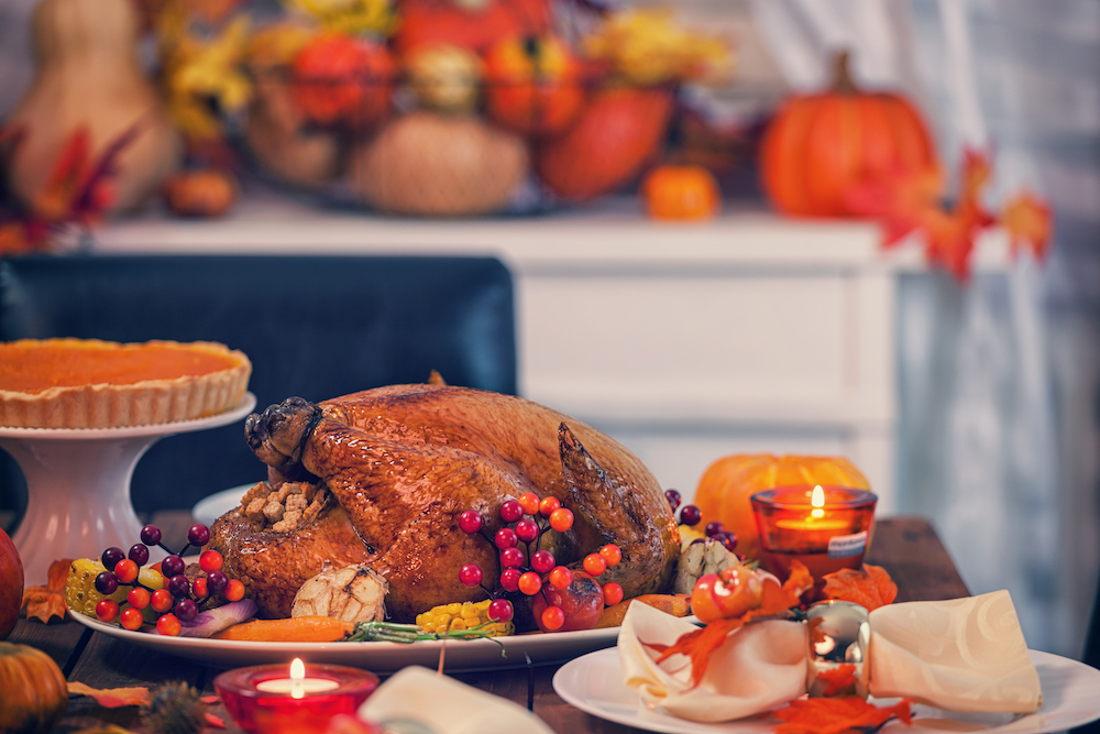 Table set for Thanksgiving dinner with focus on a turkey